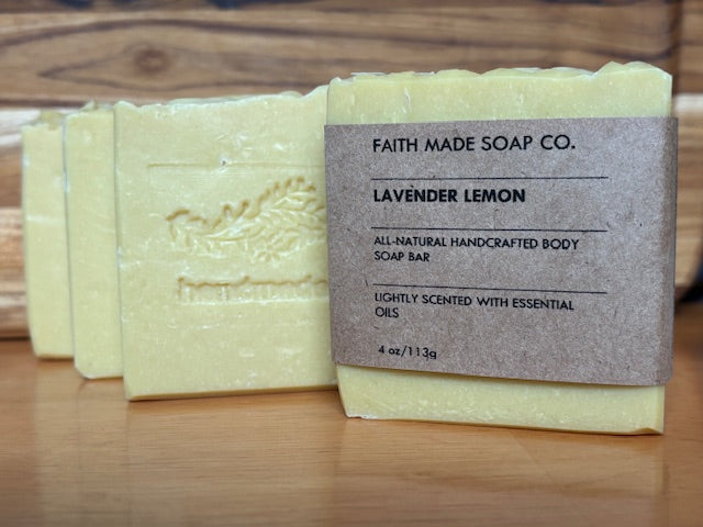 Bar of soap with a label on a wooden surface, featuring 'Faith Made Soap Co.' Lavender Lemon